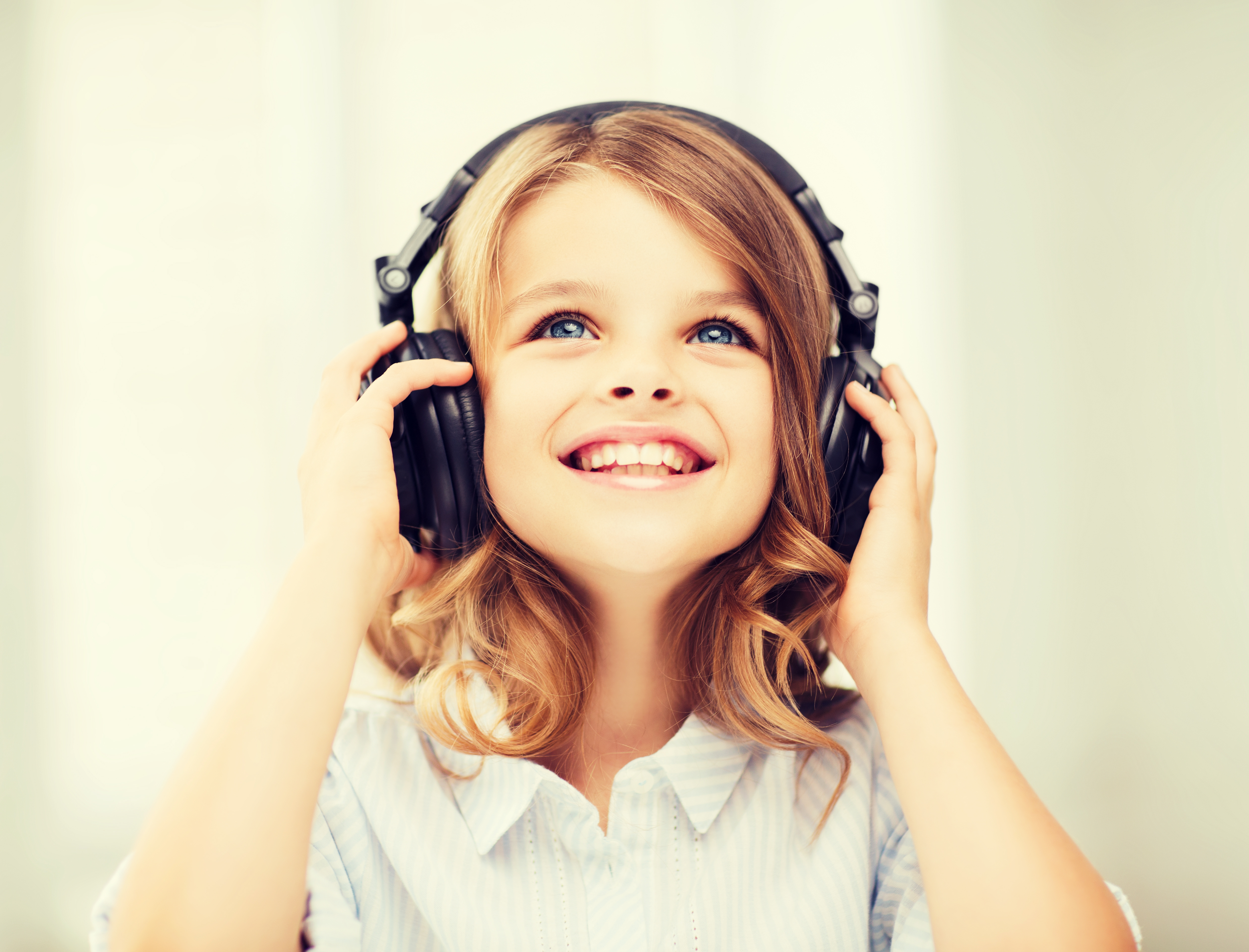 little girl with headphones at home